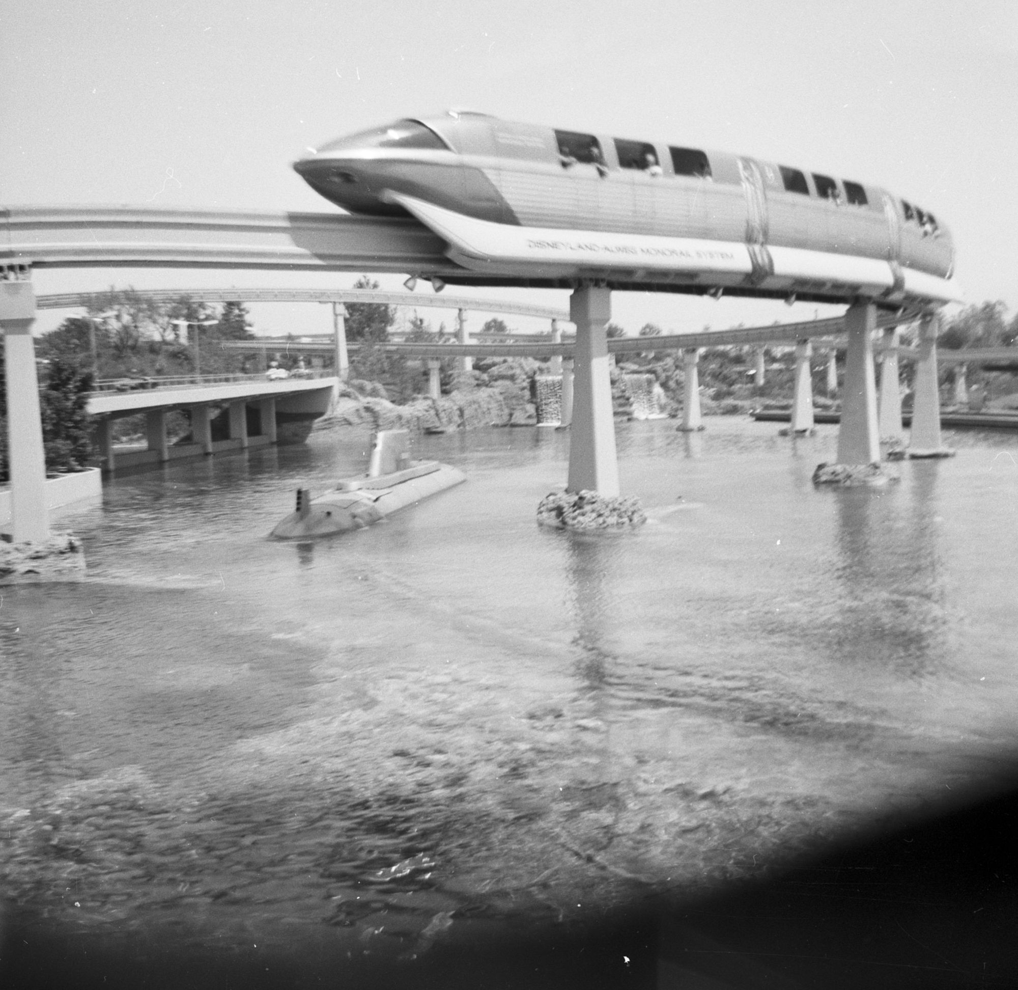 The Disneyland-Alweg Monorail passing over a Submarine Voyage boat, Tomorrowland, 1959.